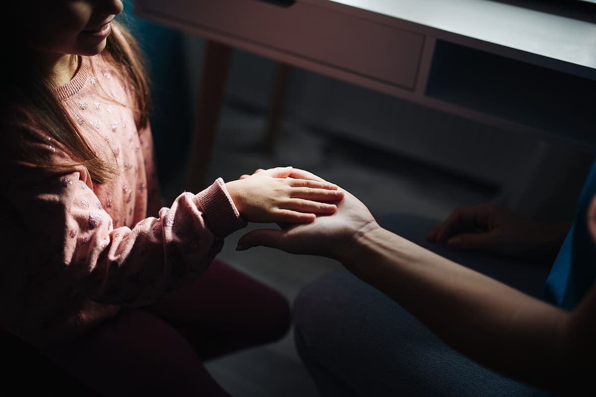 A child's hand resting in an adult's open palm